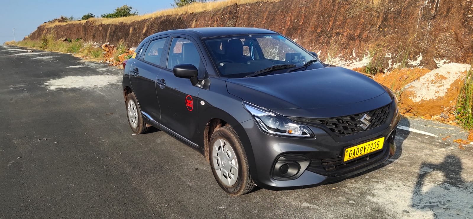 Car parked by Goa beach at sunrise.